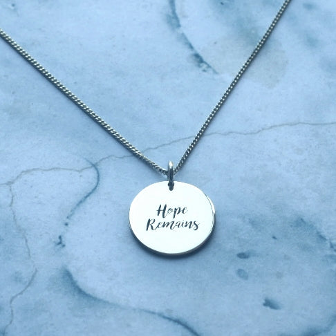 Silver 20 mm disc with a personalised motto or slogan engraved on in the font of your choice.