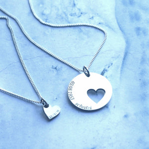 Silver mother daughter set with a 20 mm disc with a 10 mm cutout heart as separate pendant. Custom engraving can be placed on the disc up to 20 letters and on the heart up to 10 letters.