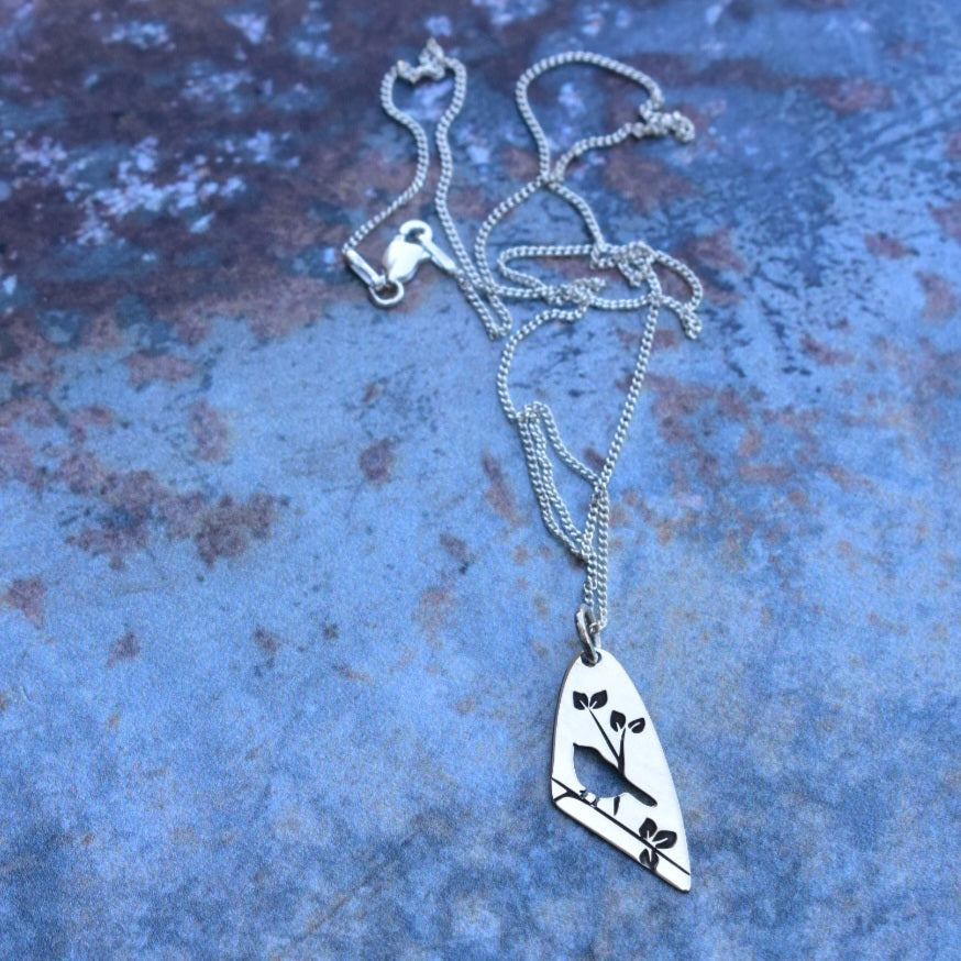 Bird on engraved branch pendant